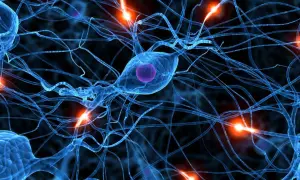 Neurones bleus interconnectés, avec des éclairs d'énergie orange. Une image qui évoque la complexité du cerveau, et la recherche sur la parkinson cause psychologique.