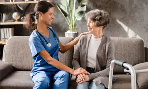 Aide-soignante réconfortant une patiente, évoquant les avantages fiscaux maladie parkinson.