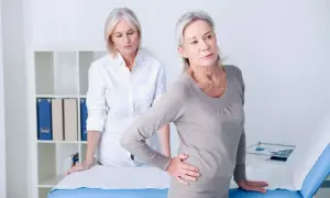 Une femme souffre de douleurs à la hanche, possiblement liées à l'arthrose. Une autre femme, peut-être une professionnelle de santé, l'observe. La musculation pourrait aider.
