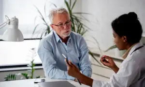Un médecin discute avec un patient, lui expliquant les détails d'un certificat médical circonstancié.