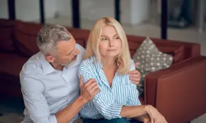Un homme réconforte une femme visiblement préoccupée. L'inconvénient de l'habilitation familiale peut peser lourdement sur les couples.