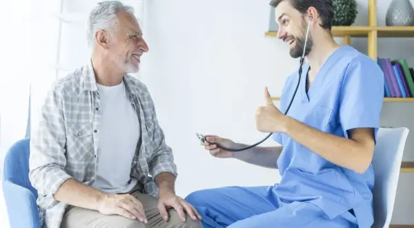 Un médecin rassure un patient âgé, lui expliquant l'espérance de vie après ablation de la prostate. Le docteur fait un pouce levé.