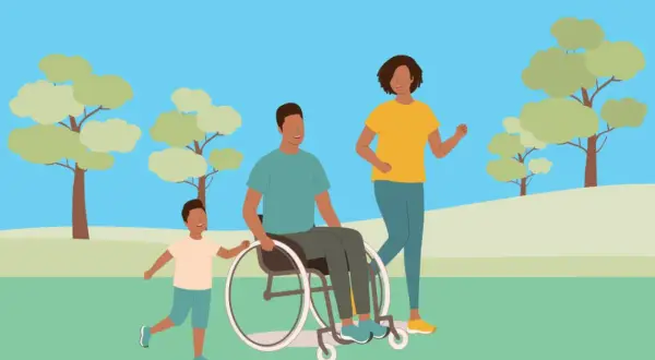 Famille heureuse au parc. Le père en fauteuil roulant, la mère et le fils profitent du soleil. Aide pour le remboursement fauteuil roulant MDPH.