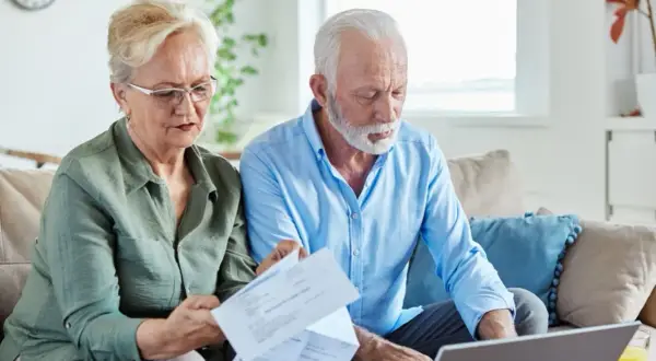 Couple âgé gérant leur compte bancaire, préoccupé par les finances, peut-être lié à l'alzheimer.