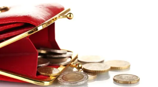 Portefeuille rouge ouvert avec des pièces tombant. Les ald inconvénients de la gestion de l'argent liquide.