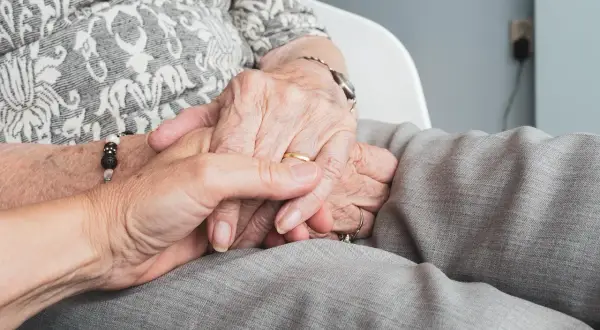Mains jointes, symbolisant le soutien et la confiance. Réfléchir aux avantages et inconvénients du mandat de protection future.