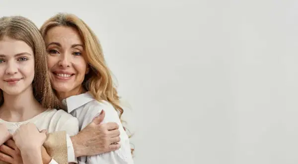 Trois générations de femmes souriantes, une grand-mère, une mère et une fille, se serrent. La mère dit : "Je ne peux pas payer les frais de notaire succession.