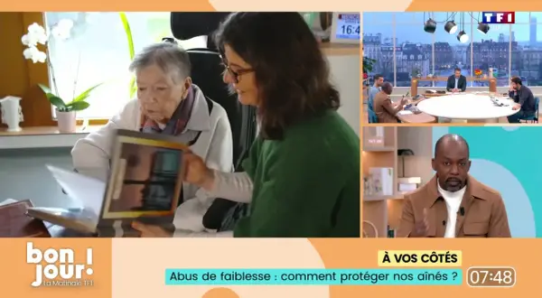 Une femme montre un album à une personne âgée, évoquant l'abus de faiblesse sur personne âgée et comment protéger nos aînés.