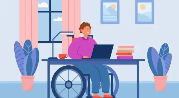 Personne en fauteuil roulant travaillant sur un ordinateur portable, cherchant des mdph aides financières pour son autonomie.