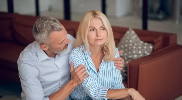Un homme réconforte une femme visiblement préoccupée. L'inconvénient de l'habilitation familiale peut peser lourdement sur les couples.