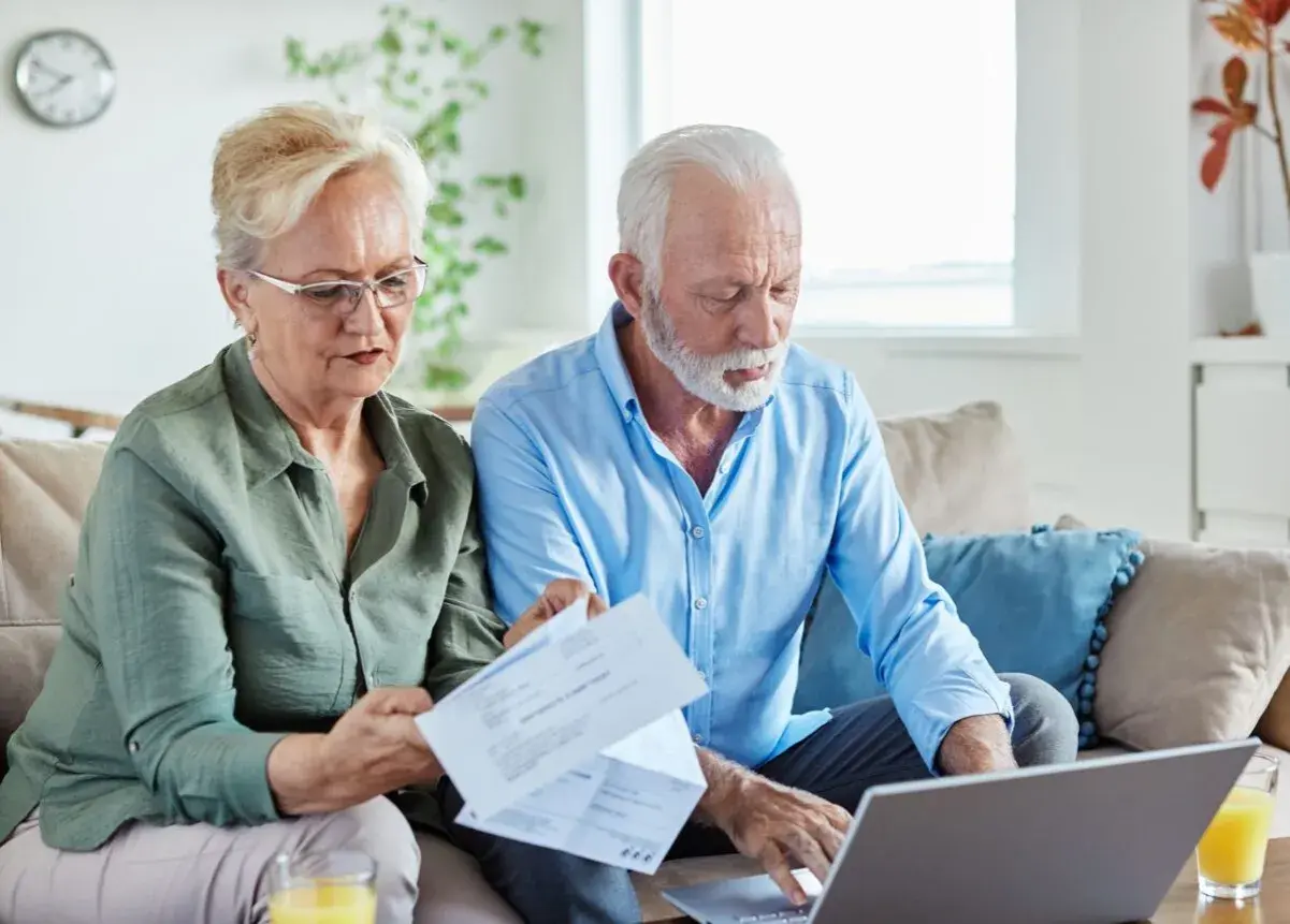 Couple âgé gérant leur compte bancaire, préoccupé par les finances, peut-être lié à l'alzheimer.