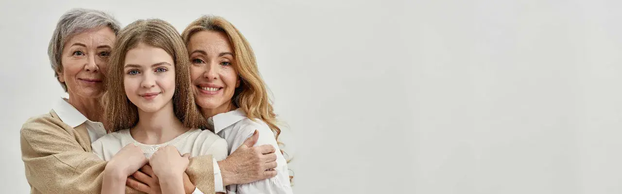 Trois générations de femmes souriantes, une grand-mère, une mère et une fille, se serrent. La mère dit : "Je ne peux pas payer les frais de notaire succession.