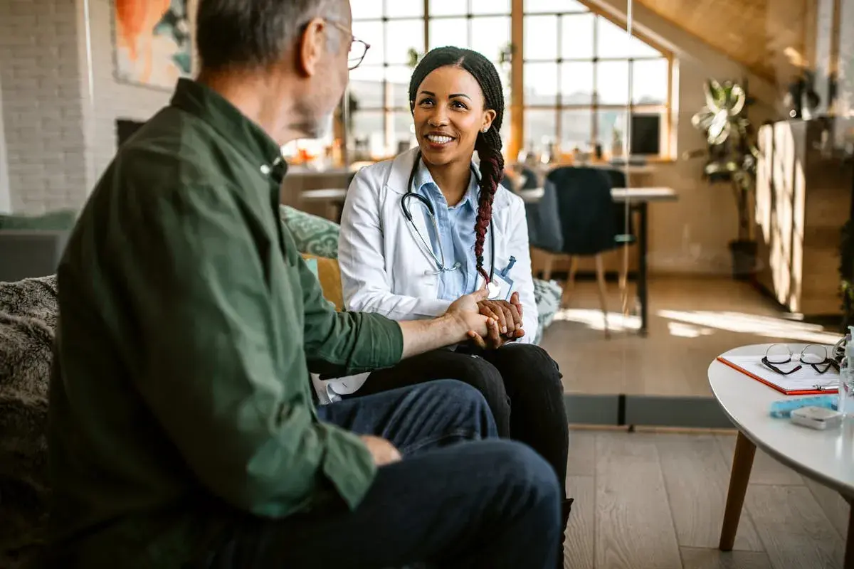 Une médecin rassure un patient, lui tenant la main. La question "peut-on sortir des soins palliatifs" est abordée avec espoir et soutien.