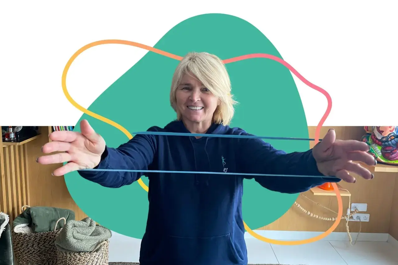 Une femme souriante fait des exercices avec un élastique, parfaite pour un programme de mise en forme 60 ans et plus.