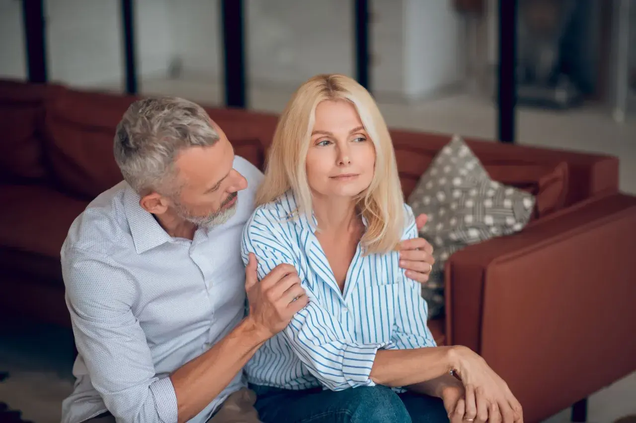 Un homme réconforte une femme visiblement préoccupée. L'inconvénient de l'habilitation familiale peut peser lourdement sur les couples.