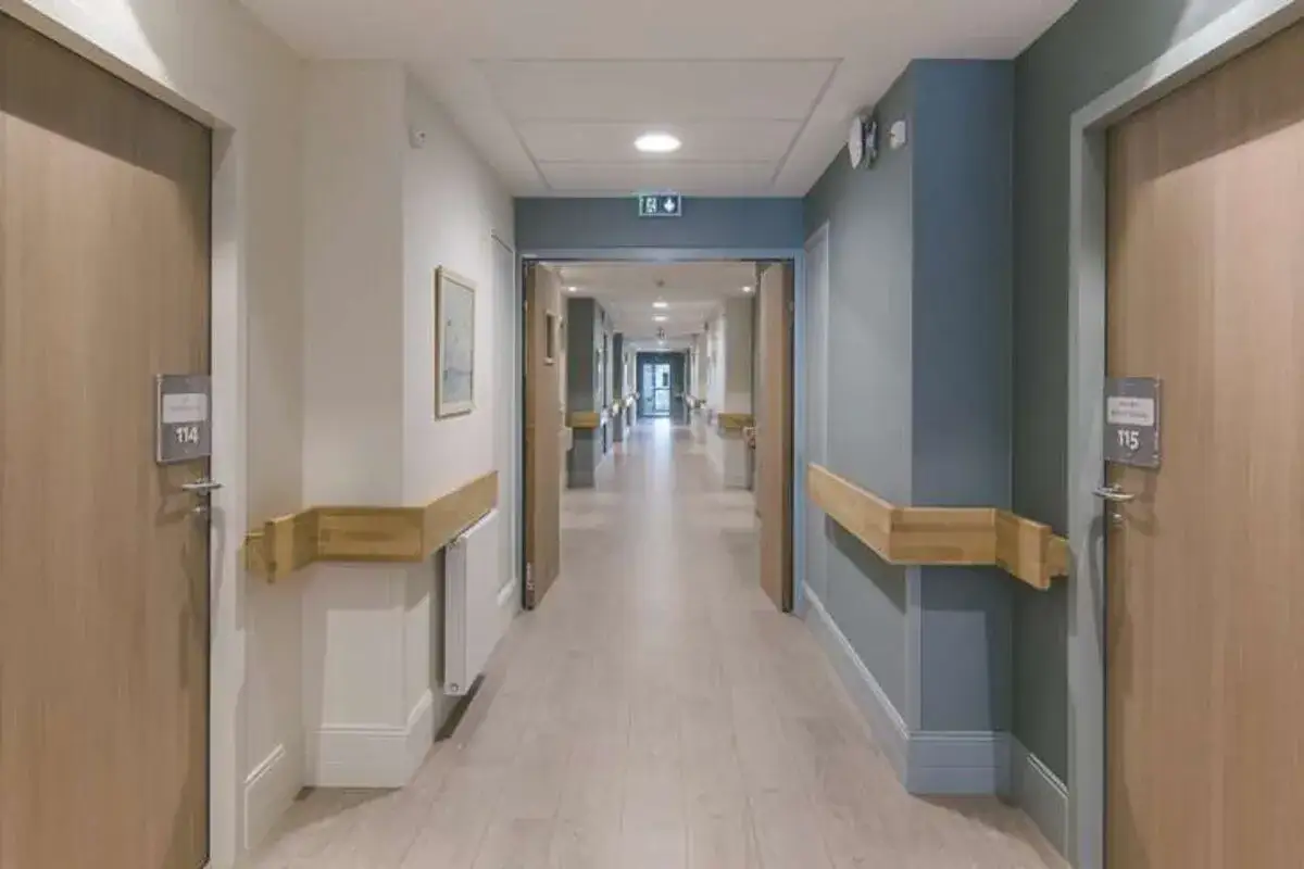 Couloir d'un établissement de santé avec des portes numérotées, rappelant une liste des UHR en France.