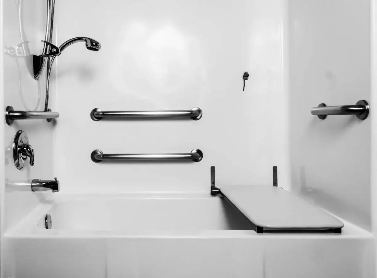 Salle de bain adapt&eacute;e avec barres d'appui et si&egrave;ge rabattable, id&eacute;ale pour un pr&ecirc;t &agrave; taux z&eacute;ro pour personne handicap&eacute;e.