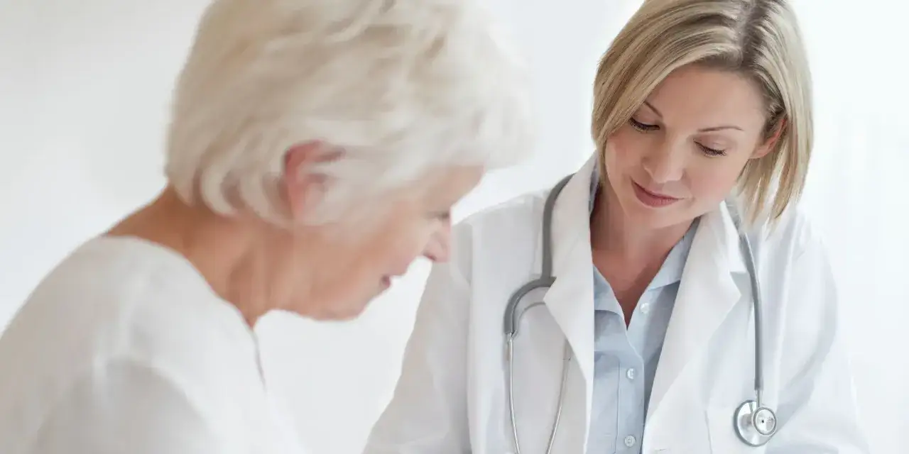 Médecin examinant un patient âgé, remplissant un certificat médical circonstancié.