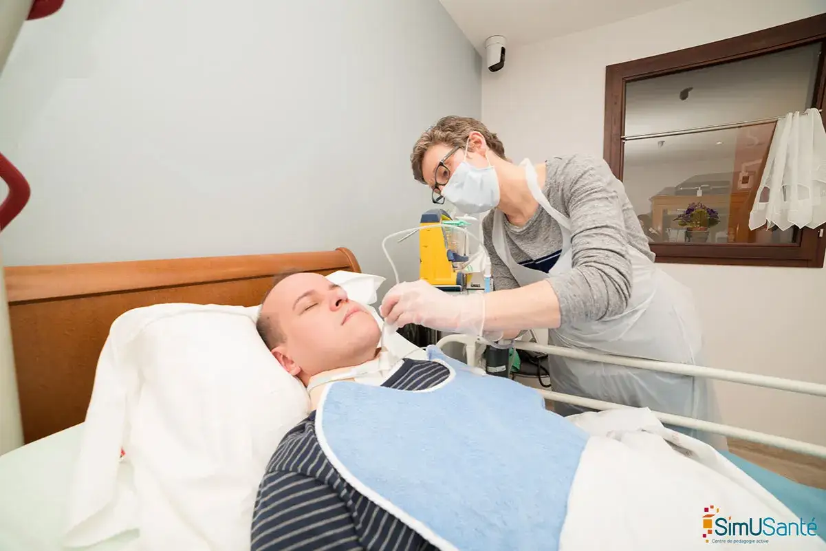 Soins &agrave; domicile pour un patient en phase terminale de cancer. Une infirmi&egrave;re ajuste la canule de trach&eacute;otomie.