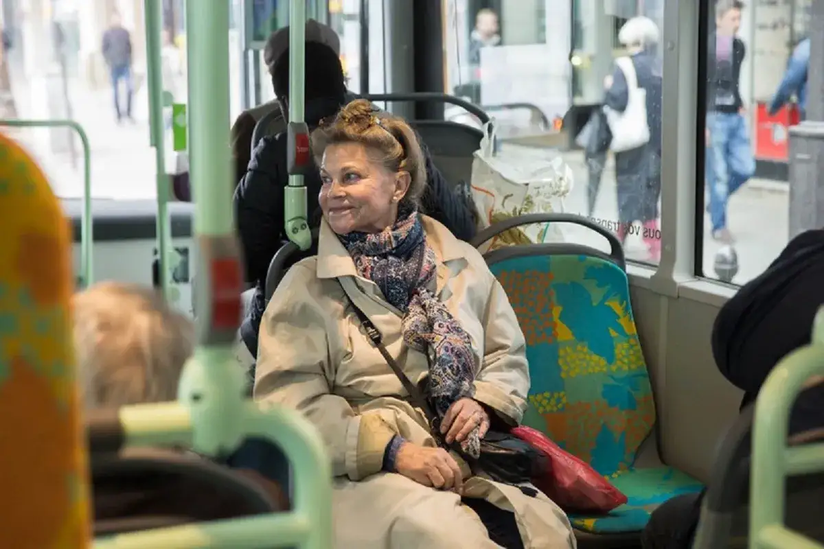 Une femme &acirc;g&eacute;e profite du transport gratuit pour personne &acirc;g&eacute;e, souriante dans le bus.