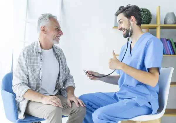 Un médecin rassure un patient âgé, lui expliquant l'espérance de vie après ablation de la prostate. Le docteur fait un pouce levé.