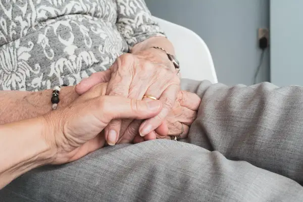Mains jointes, symbolisant le soutien et la confiance. Réfléchir aux avantages et inconvénients du mandat de protection future.
