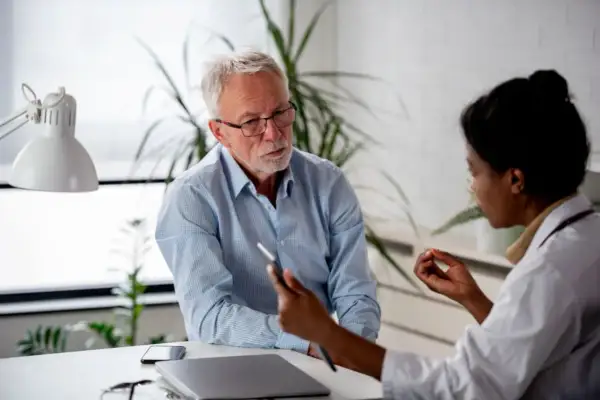 Un médecin discute avec un patient, lui expliquant les détails d'un certificat médical circonstancié.